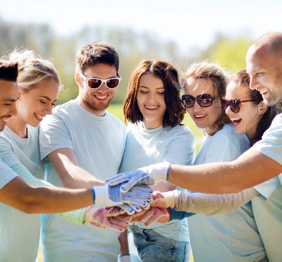 A group of people holding hands in the middle of a circle.